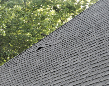 Wind damaged shingles on a roof in Oklahoma City