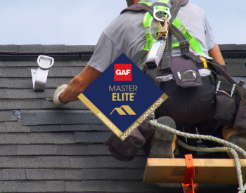 Professional roofer in Norman repairing a roof with GAF Master Elite Certification badge